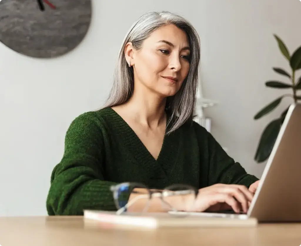 Woman works on a laptop in an open concept office space